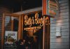 Entrance of Betty's Burgers restaurant with illuminated signage and open door at night.
