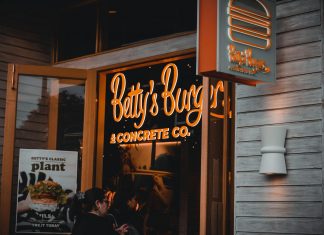 Best Burgers in Jersey City in 2026: A Local’s Guide to Juicy Patties & Hidden Gems Entrance of Betty's Burgers restaurant with illuminated signage and open door at night.