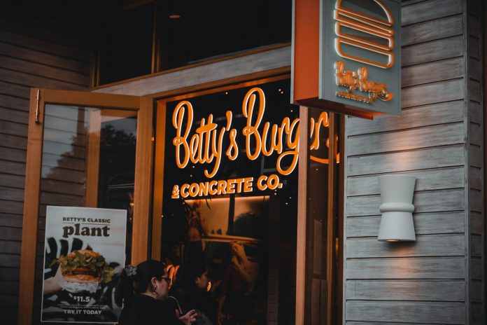 best-burgers-jersey-city-2026 Entrance of Betty's Burgers restaurant with illuminated signage and open door at night.