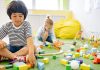 Kids enjoying playtime with toys and blocks in a bright kindergarten classroom.