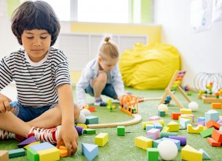 Kids enjoying playtime with toys and blocks in a bright kindergarten classroom.