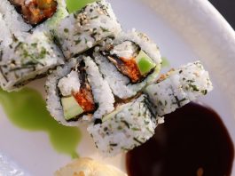 Appetizing sushi rolls with avocado, seaweed, and sesame seeds.