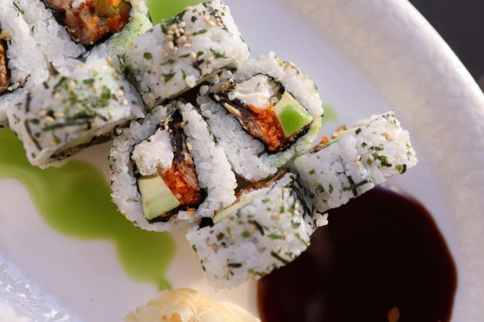 Appetizing sushi rolls with avocado, seaweed, and sesame seeds.