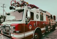 Red and white fire truck from New Braunfels Fire Department parked outdoors.