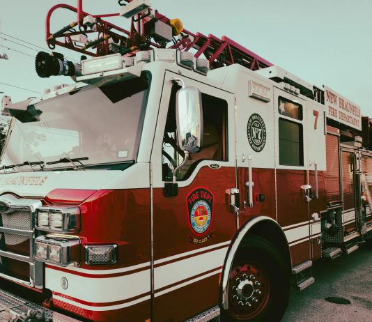 Red and white fire truck from New Braunfels Fire Department parked outdoors.