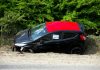 A black and red car, marked by police, abandoned off a road in Welwyn Garden City, UK.