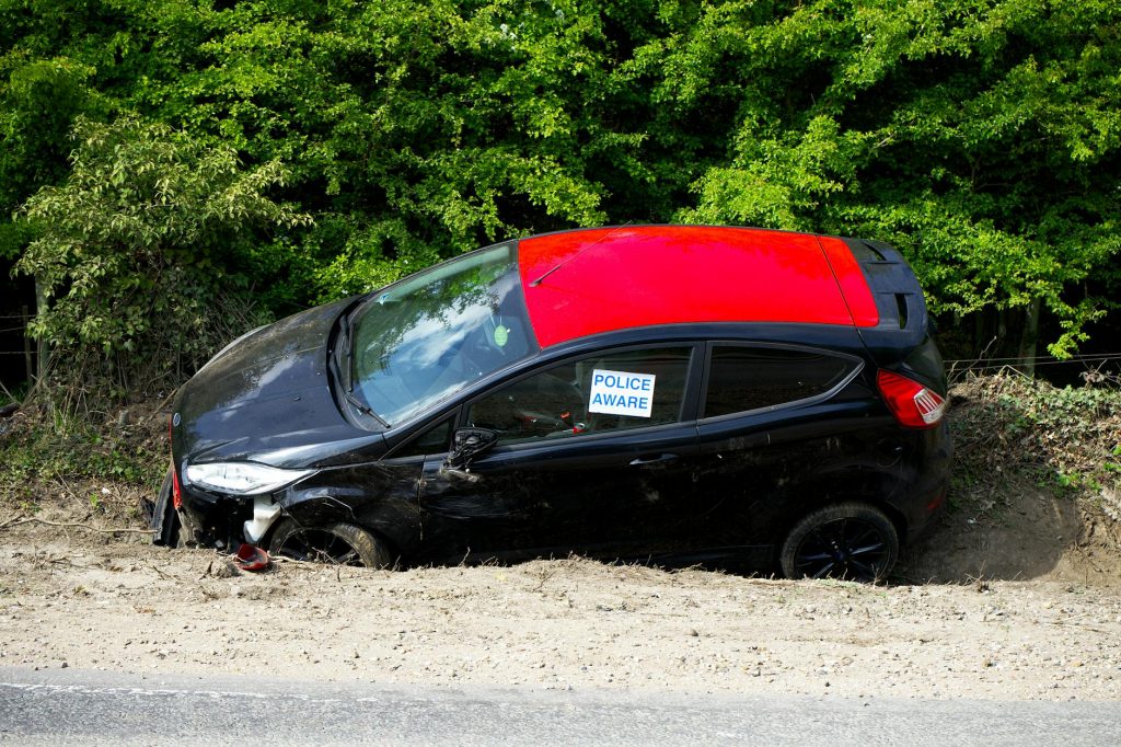 A black and red car, marked by police, abandoned off a road in Welwyn Garden City, UK.