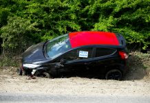 A black and red car, marked by police, abandoned off a road in Welwyn Garden City, UK.