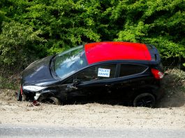 A black and red car, marked by police, abandoned off a road in Welwyn Garden City, UK.