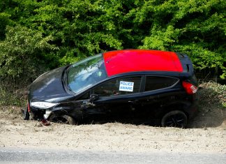 A black and red car, marked by police, abandoned off a road in Welwyn Garden City, UK.