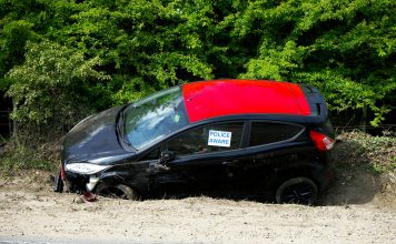 A black and red car, marked by police, abandoned off a road in Welwyn Garden City, UK.