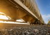 Low-angle view of a freight train with sunlight shining through, captured in Reads Landing, MN.