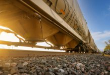 Low-angle view of a freight train with sunlight shining through, captured in Reads Landing, MN.