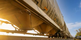 Low-angle view of a freight train with sunlight shining through, captured in Reads Landing, MN.