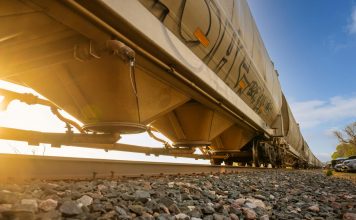 Low-angle view of a freight train with sunlight shining through, captured in Reads Landing, MN.