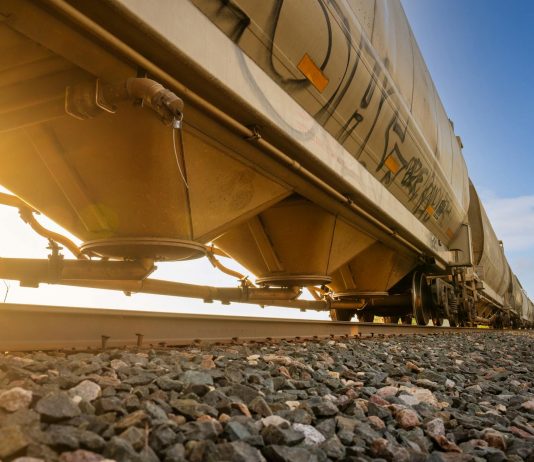 Low-angle view of a freight train with sunlight shining through, captured in Reads Landing, MN.