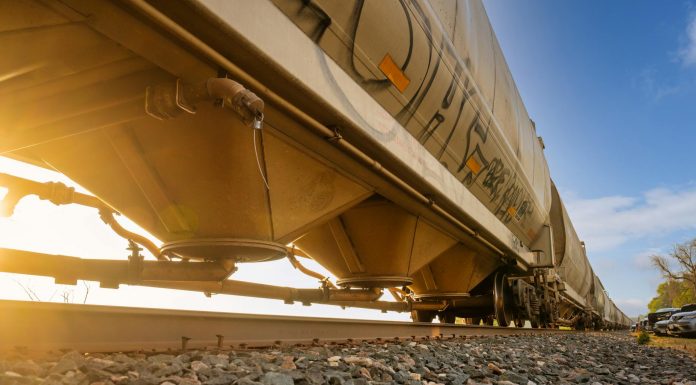 Low-angle view of a freight train with sunlight shining through, captured in Reads Landing, MN.