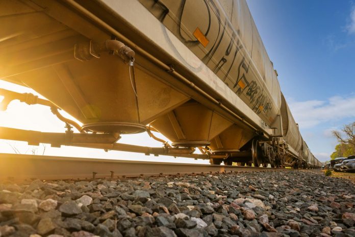 Low-angle view of a freight train with sunlight shining through, captured in Reads Landing, MN.