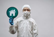 BREAKING: New Virus Outbreak in 2026 Under Watch A person in protective gear with a stay safe home symbol, promoting health and safety.