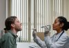 BREAKING: NJ’s First Street Medicine Program Launches to Aid Unhoused A doctor examining a patient's throat in a clinical setting, highlighting professional healthcare.