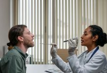 BREAKING: NJ’s First Street Medicine Program Launches to Aid Unhoused A doctor examining a patient's throat in a clinical setting, highlighting professional healthcare.