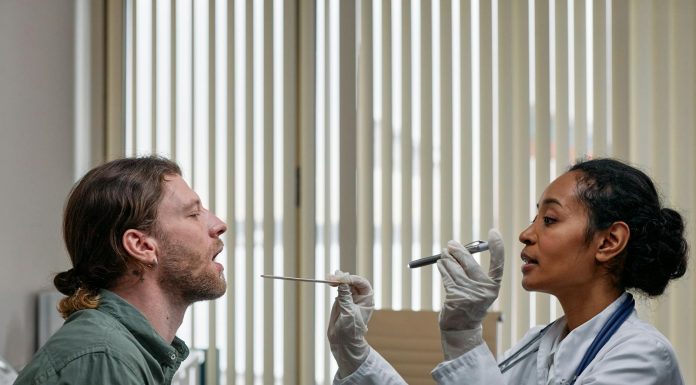 BREAKING: NJ’s First Street Medicine Program Launches to Aid Unhoused A doctor examining a patient's throat in a clinical setting, highlighting professional healthcare.