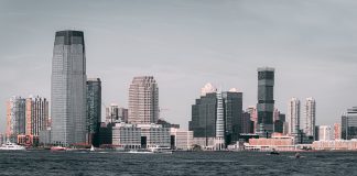 A breathtaking view of Jersey City's skyline from across the Hudson River with modern skyscrapers and waterfront buildings.