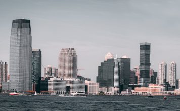 A breathtaking view of Jersey City's skyline from across the Hudson River with modern skyscrapers and waterfront buildings.