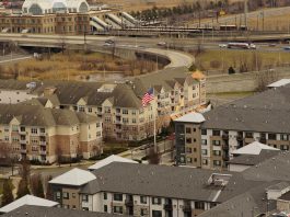 Aerial view of urban residential apartments featuring an American flag, depicting city life.
