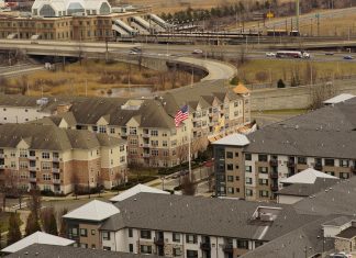 Aerial view of urban residential apartments featuring an American flag, depicting city life.