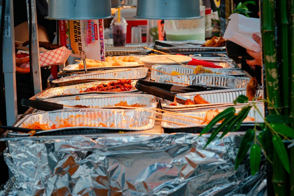 Explore a diverse range of delicious Asian street food at a bustling outdoor market stall.