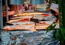 Explore a diverse range of delicious Asian street food at a bustling outdoor market stall.