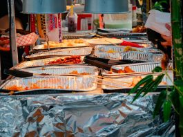 Explore a diverse range of delicious Asian street food at a bustling outdoor market stall.