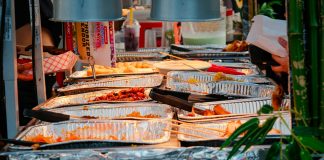 Explore a diverse range of delicious Asian street food at a bustling outdoor market stall.