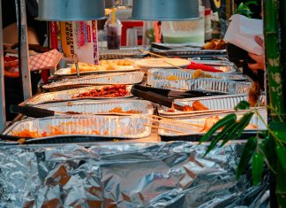 Explore a diverse range of delicious Asian street food at a bustling outdoor market stall.
