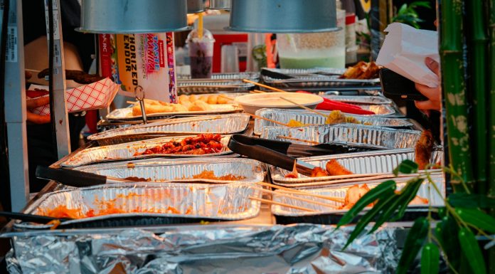 Explore a diverse range of delicious Asian street food at a bustling outdoor market stall.