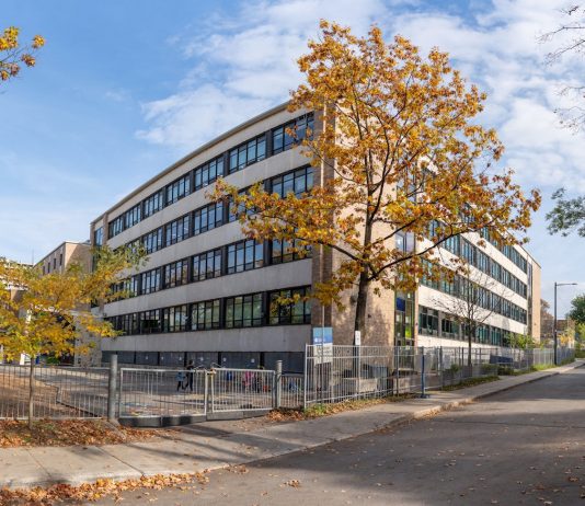 A school building in Québec city surrounded by colorful autumn trees.