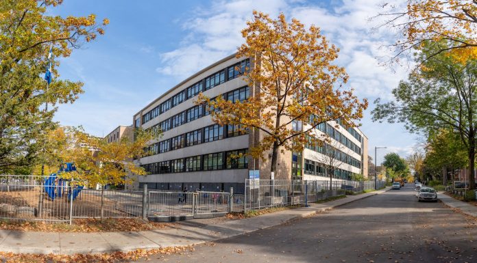 A school building in Québec city surrounded by colorful autumn trees.