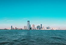Panoramic view of Manhattan skyline with modern skyscrapers under a clear blue sky.