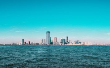 Panoramic view of Manhattan skyline with modern skyscrapers under a clear blue sky.