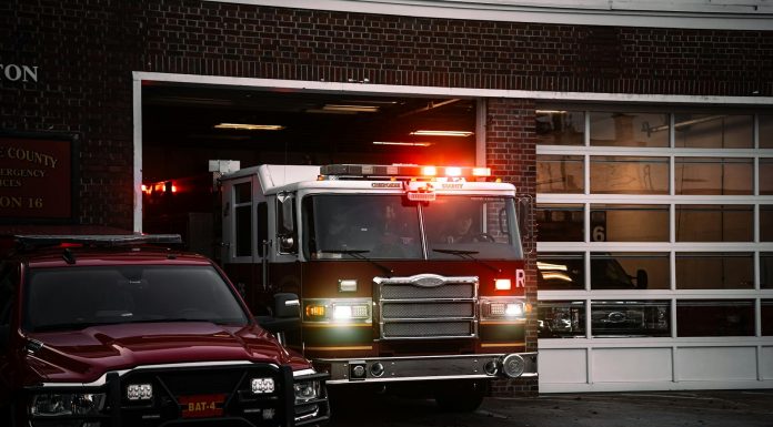 A fire truck exits the station, lights flashing, ready for emergency response.