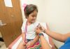 Measles case confirmed in New Jersey—here’s what Hudson County families need to know A cheerful young girl receives a band-aid after a vaccination at a clinic.