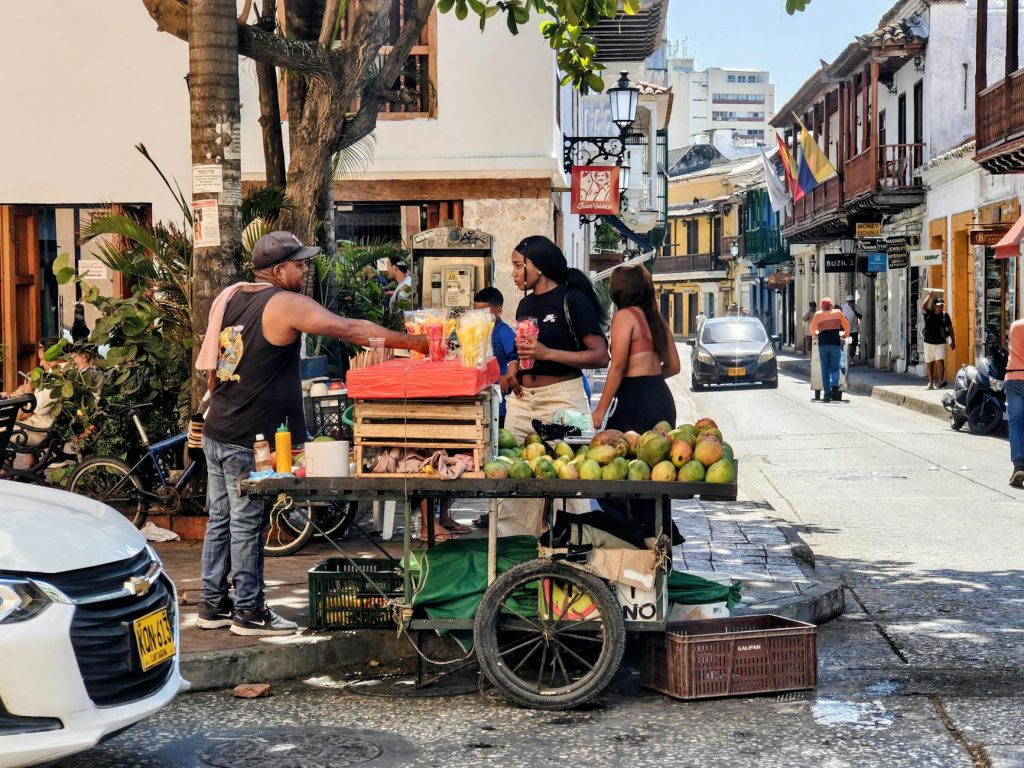 Vibrant street market scene with a fruit vendor in Cartagena, Colombia's historic district.