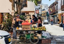 Vibrant street market scene with a fruit vendor in Cartagena, Colombia's historic district.