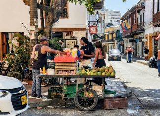 Mejor Comida Colombiana en Jersey City: Guía 2026 de Sabores Auténticos en el Condado de Hudson Vibrant street market scene with a fruit vendor in Cartagena, Colombia's historic district.