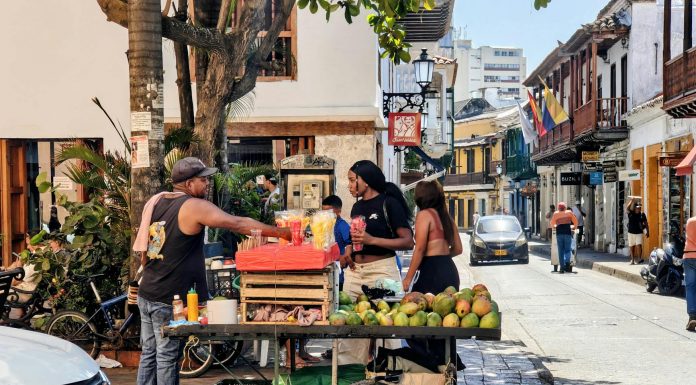 Vibrant street market scene with a fruit vendor in Cartagena, Colombia's historic district.