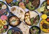 A vibrant spread of Middle Eastern dishes with fresh salads and drinks, captured in Vancouver.
