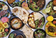 A vibrant spread of Middle Eastern dishes with fresh salads and drinks, captured in Vancouver.