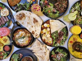 A vibrant spread of Middle Eastern dishes with fresh salads and drinks, captured in Vancouver.