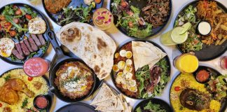 A vibrant spread of Middle Eastern dishes with fresh salads and drinks, captured in Vancouver.